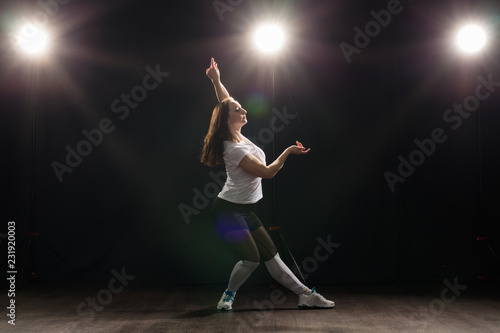 Dance  hip-hop  jazz funk and people concept - flexible young woman dancing in the darkness under the light
