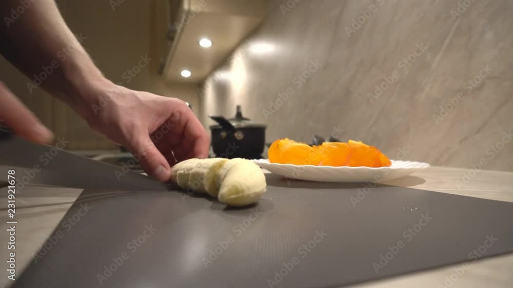 Father is cutting fresh organic banana for his children for afternoon snack Father is cutting fresh organic banana for his children for afternoon snack