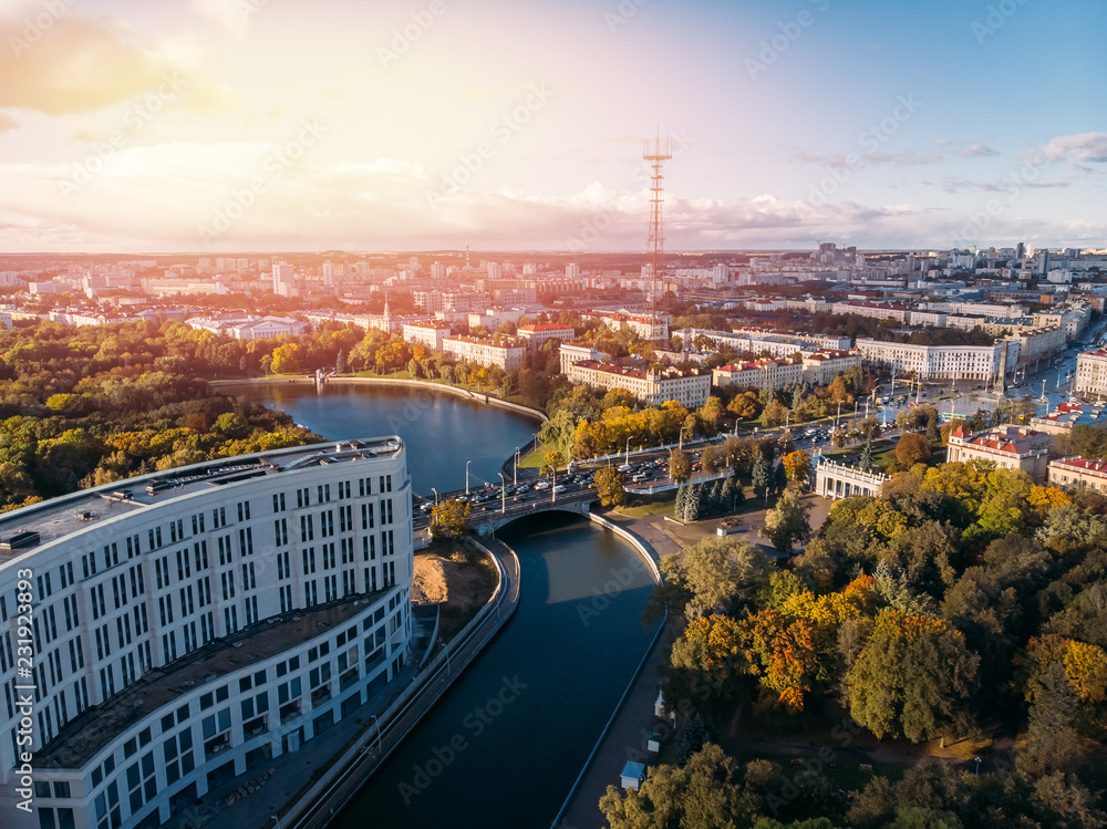 Obraz premium Minsk, Republic Belarus on Sunny autumn day. River is in middle between Park with yellowed trees