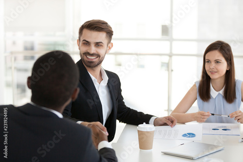 Wallpaper Mural Smiling Caucasian man handshake black colleague getting acquainted at office meeting, multiethnic employees shake hands greeting or introducing at briefing, male worker congratulate coworker Torontodigital.ca
