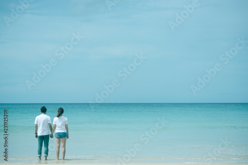 Back view of asian couple holding hand standing in sea on honeymoon period,mood and tone with valentine concept. © mkitina4