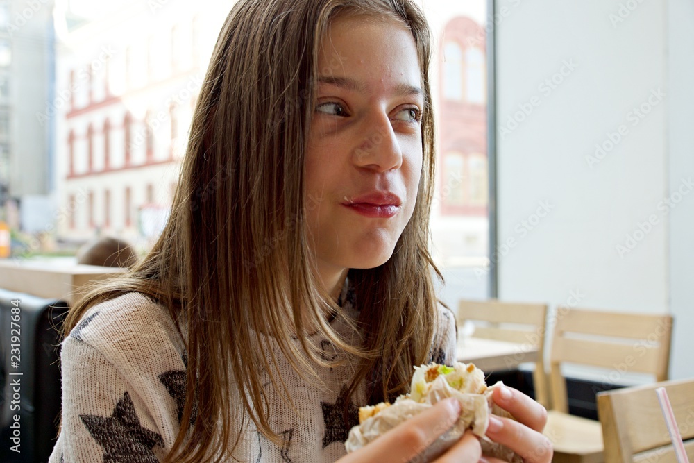 portrait of young woman eating sandwich