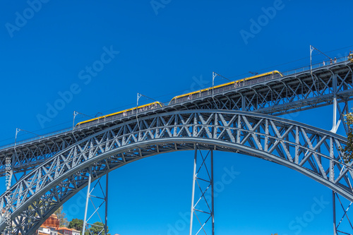 View of the metallic bridge of D. Maria Pia, built by Gustave Eiffel, with yellow subway wagon, in Porto