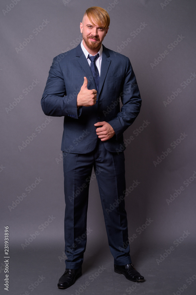 Bearded businessman with blond hair against gray background Bearded businessman with blond hair against gray background