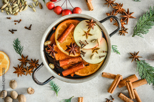 Christmas mulled wine with apple, orange and spices, hot drink, cooking in a pot