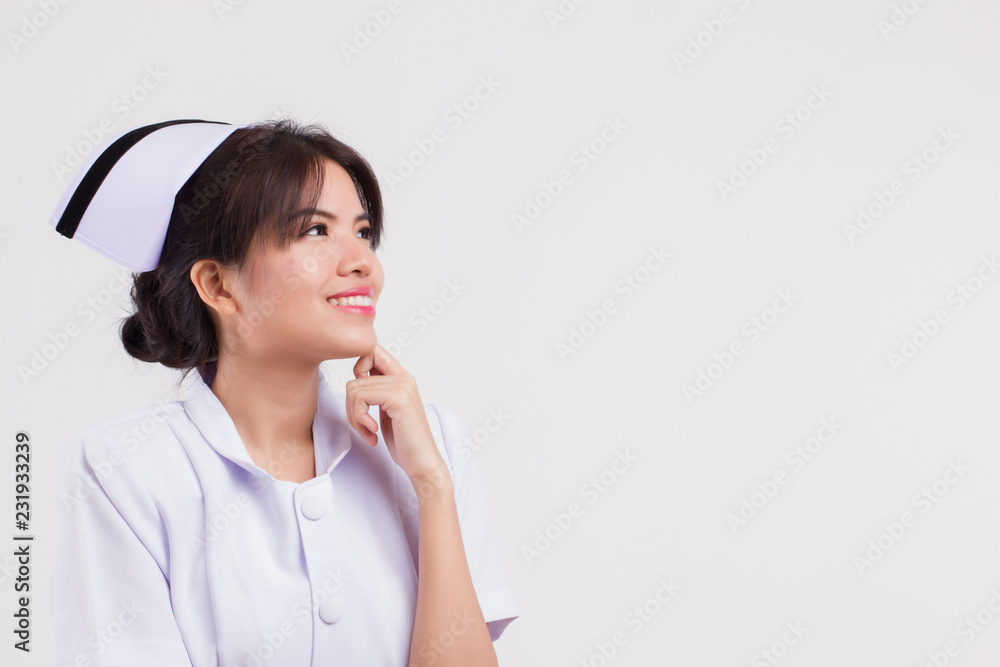 happy smiling nurse thinking and looking up. portrait of joyful, positive, happy, smiling asian woman nurse planning, finding idea, thinking on studio white isolated background happy smiling nurse thinking and looking up. portrait of joyful, positive, happy, smiling asian woman nurse planning, finding idea, thinking on studio white isolated background