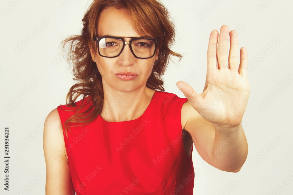 Pretty woman hand stop sign body language enough concept in red dress isolated on white Pretty woman hand stop sign body language enough concept in red dress isolated on white