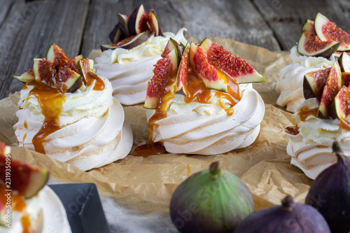 Small figs pavlova with whipped cream and caremel glaze on baking paper