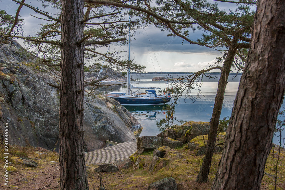 Sailboat at anchor in a lonely bay of Gubboe Kupa Skerry island in the Stockholm skerry gardenm Swedish east coast