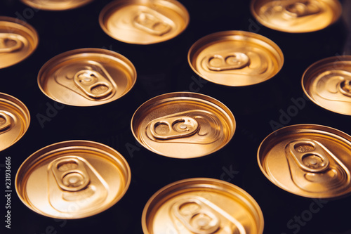 metal beer cans background black gold