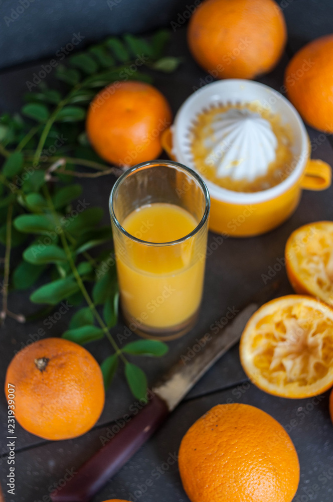 Oranges and juicer for making orange juice.. Black-gray background. Oranges and juicer for making orange juice.. Black-gray background.