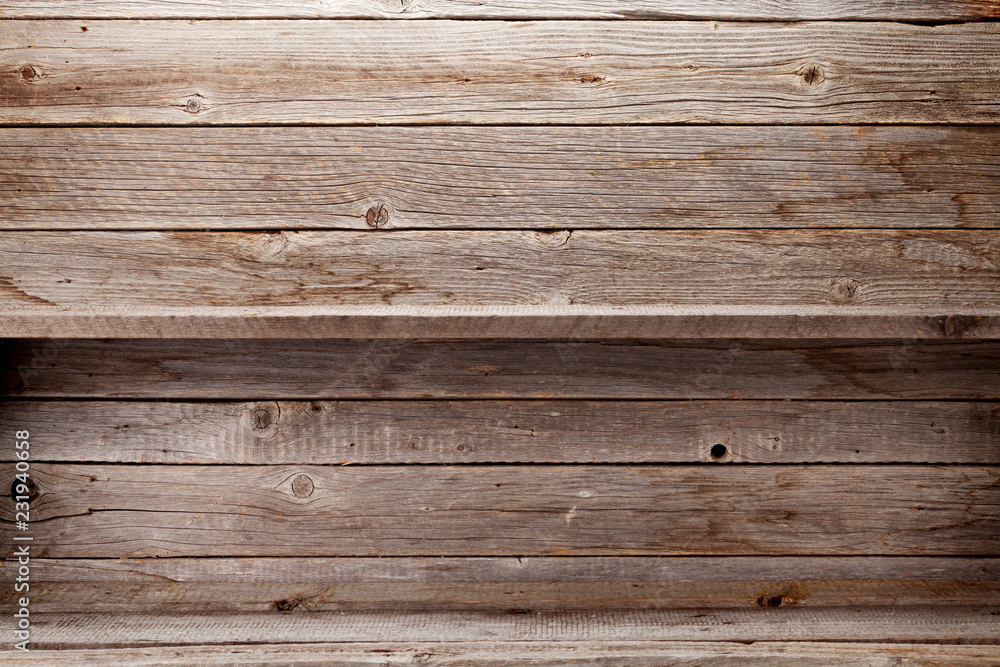 Empty wooden shelves in front of wooden wall