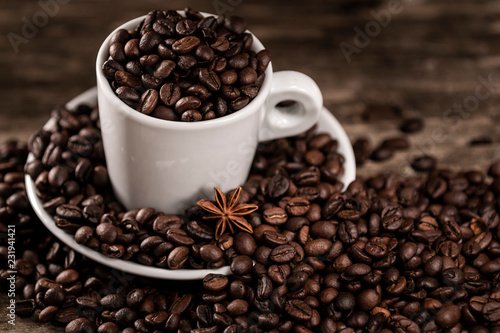 White cup covered coffee beans with star anise