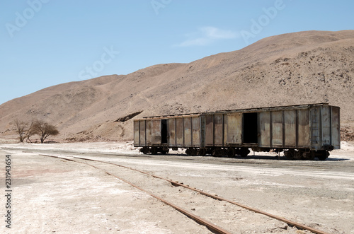 Abandoned old train carriage in the middle of the desert photo