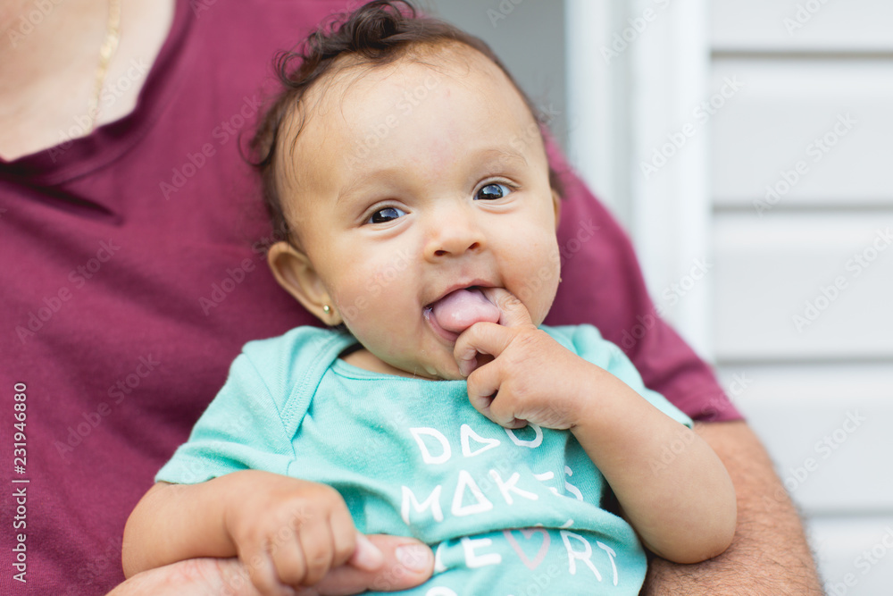 Portrait of a cute baby girl smiling happily as she is held by her father Portrait of a cute baby girl smiling happily as she is held by her father