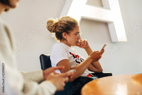 Casual woman using her smartphone at modern office. photo