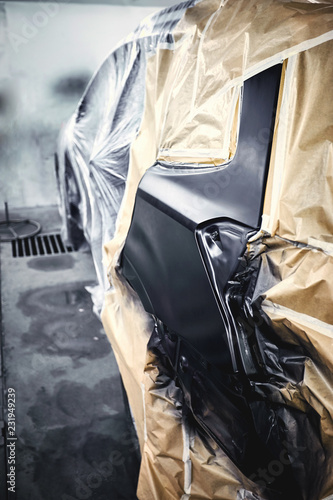 Painting the car in black color in the paint chamber on the service..