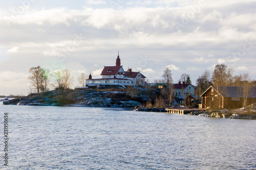 Tiny islands with historical buildings near the island Suomenlinna in Helsinki in Finland on a sunny winter day with snow.