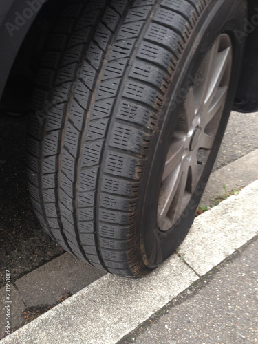 Auto parkt nur halb auf der Bordsteinkante, der Reifen rutscht langsam ab © HeiSpa