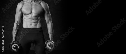 Fitness muscular body on dark background. Photo with copy space for text