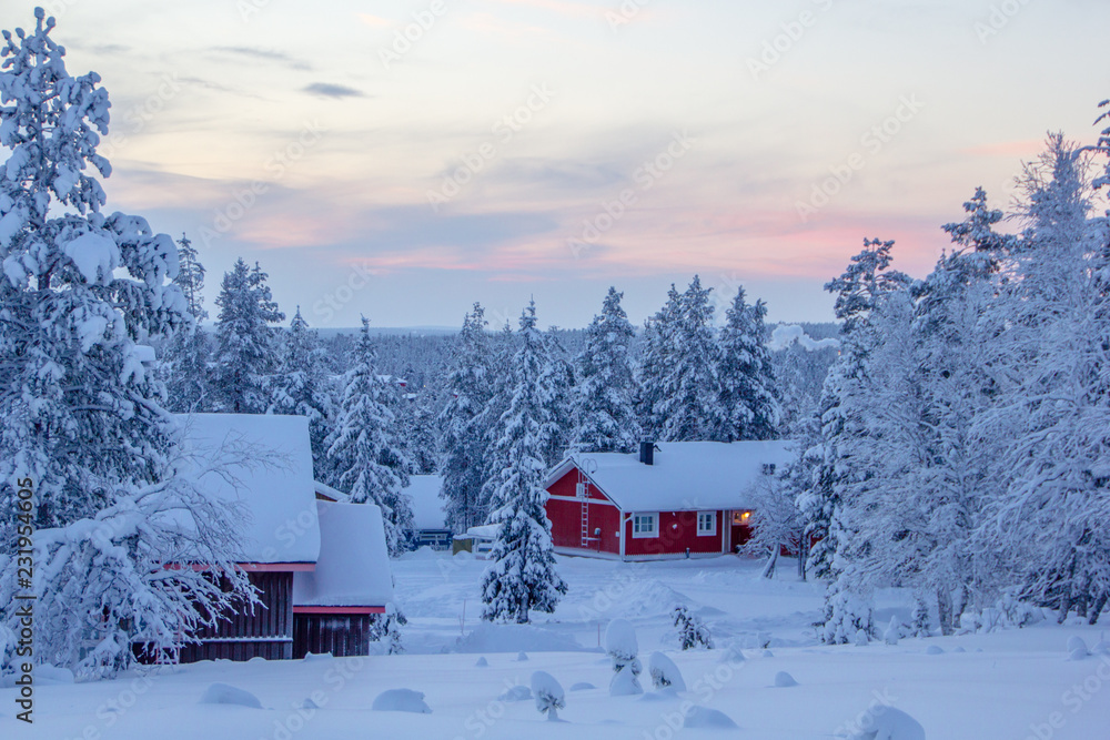Winter landscape scenery in Lapland, Scandinavia with snow and traditional houses