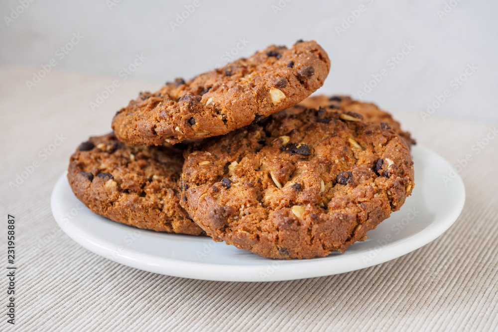 Chocolate chip cookies on rustic dark black background. Stacked chocolate chip cookies on brown napkin. Symbolic image with place for text. Freshly baked. Concept for a tasty snack. Sweet dessert. Chocolate chip cookies on rustic dark black background. Stacked chocolate chip cookies on brown napkin. Symbolic image with place for text. Freshly baked. Concept for a tasty snack. Sweet dessert.