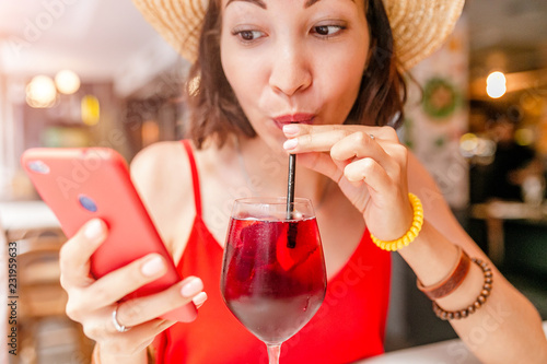 Traveler woman drink sangria and using smartphone in spanish cafe