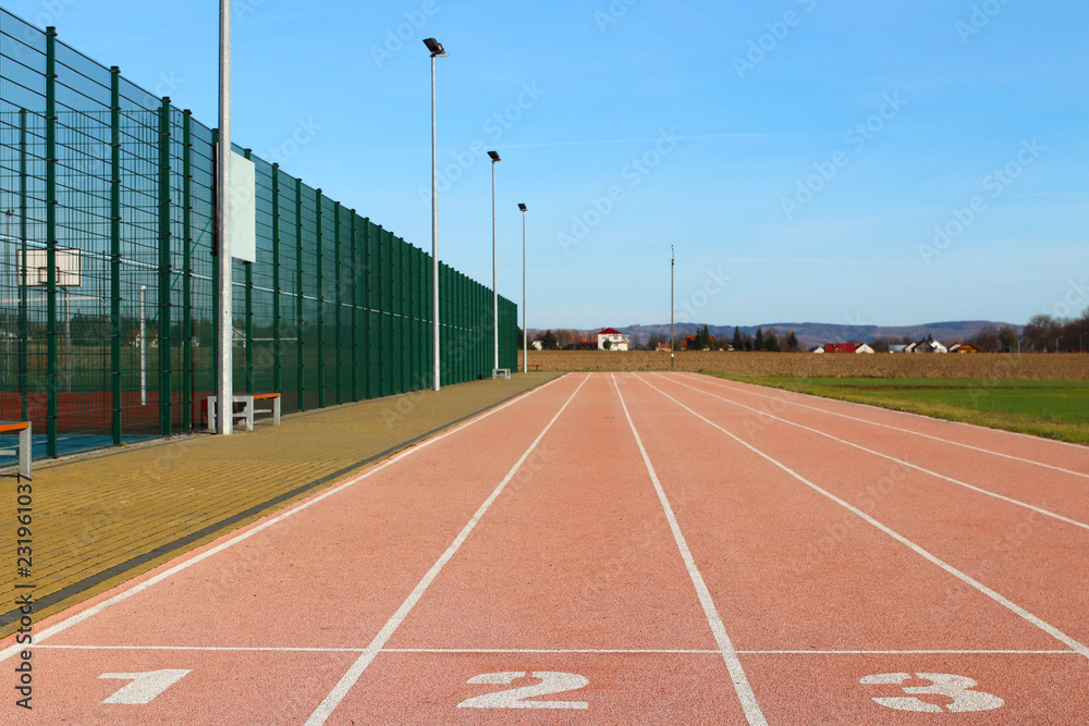 Obraz premium Red treadmill at the stadium. Element of a sports complex. Outdoor coating for sports. A place for competitions in athletics. 1, 2, 3 - start track numbers