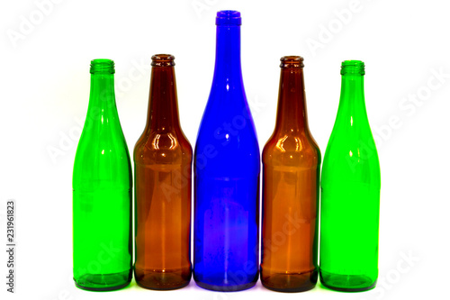 Colored empty glass bottles on white background