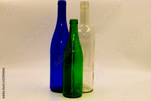 Colored empty glass bottles on white background