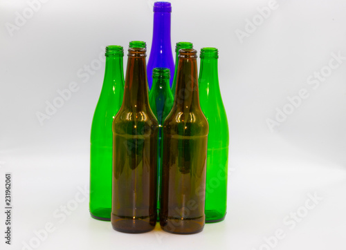 Colored empty glass bottles on white background