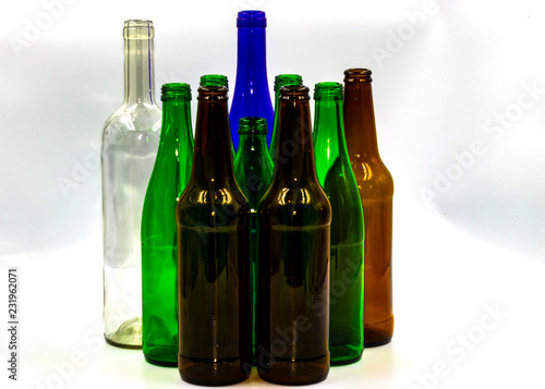 Colored empty glass bottles on white background