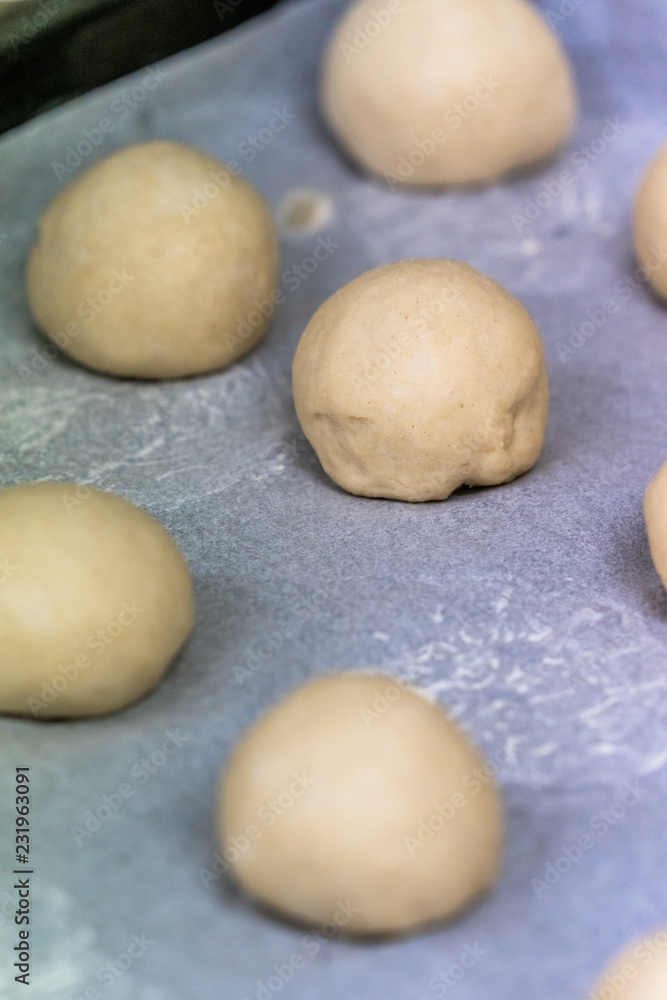 Small Bread Dough Balls Placed on Cooking Paper on Pan - Ready to be Baked