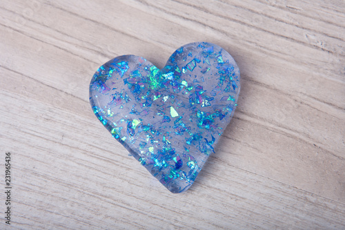 Heart shape glitter slime on a wooden table