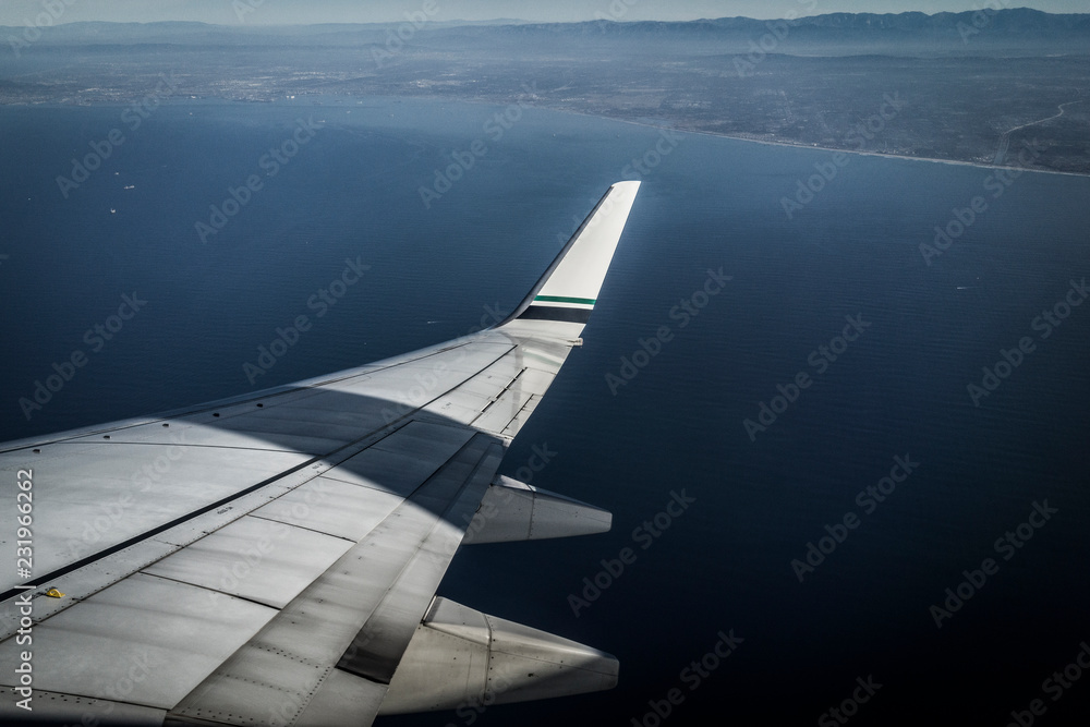 wing of an airplane flying above the clouds wing of an airplane flying above the clouds