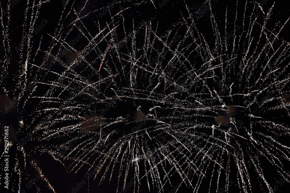 Obraz premium Fireworks in the night sky. Texture salute. Abstract photo of flares on a black background. Photos of lights salute in the sky. Image of salute flashes. Texture of colored lights.