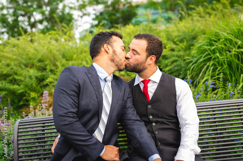 A Handsome gay male couple in the park on their wedding day
