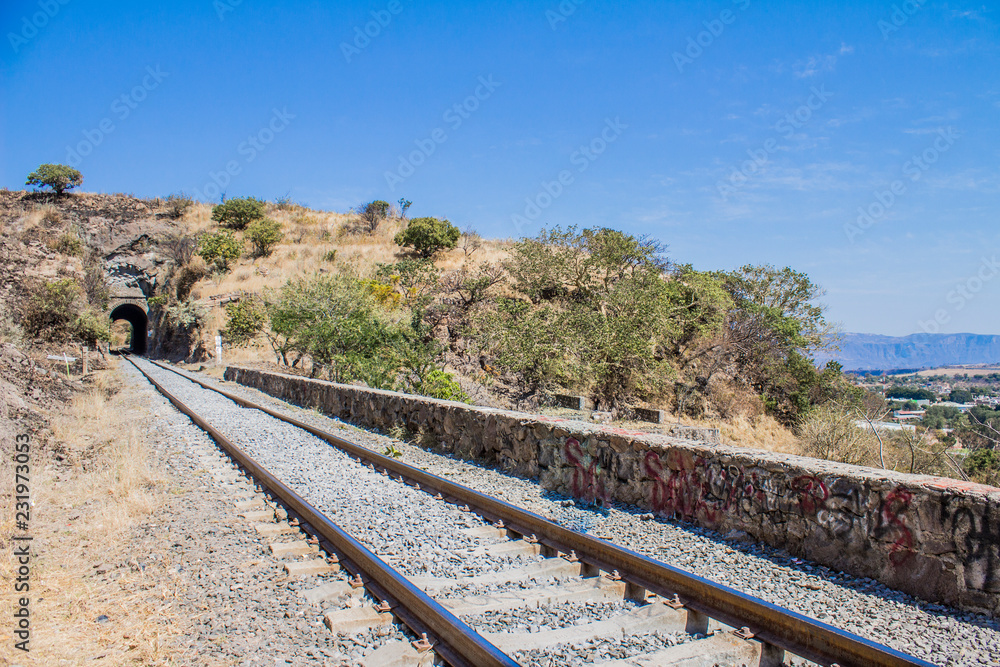 beautiful image of the tracks of a train that lead to the town of Tequila Jalisco Mexico with an impressive blue sky and a tunnel in the background beautiful image of the tracks of a train that lead to the town of Tequila Jalisco Mexico with an impressive blue sky and a tunnel in the background