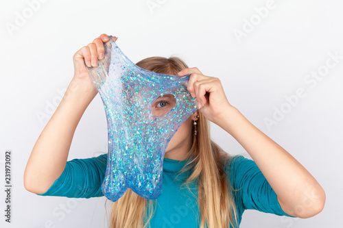 Fotografia Funny girl holdin a glitter slime in front of her face and looking through its hole