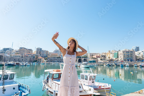 Elegant young tourist visitor woman walking on a sightseeing tour at Heraklion Venetian port, Crete, Greece