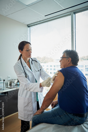 Doctor giving male patient a shot in the arm