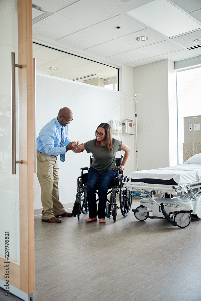 Man helping woman out of wheelchair Man helping woman out of wheelchair