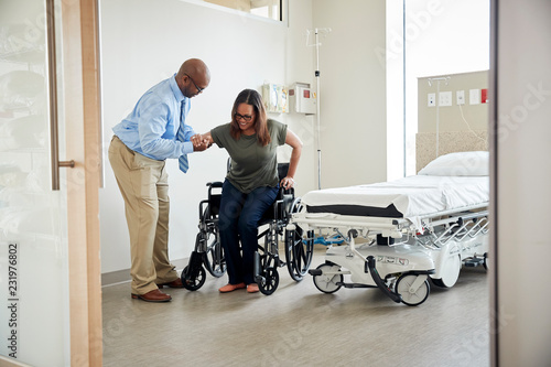 Man helping woman out of a wheelchair
