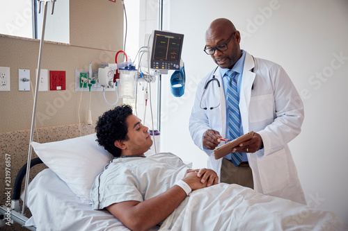 Patient talking to doctor while lying a hospital bed