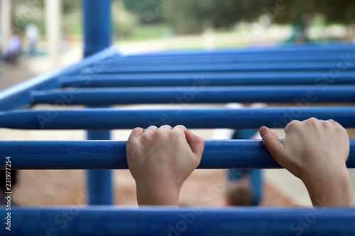 Children's hands on monkey bars