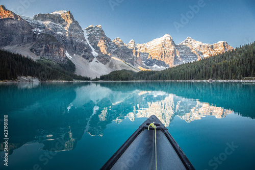 Paddling canoe on Moraine Lake during sunrise, Canadian Rockies, Canada