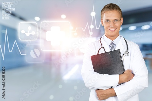 Young handsome doctor on light background