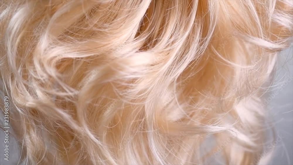 Hair. Beautiful healthy long curly blond hair closeup texture. Dyed wavy blonde hair background. Coloring concept. Haircare. Slow motion 4K UHD video footage. 3840X2160 Hair. Beautiful healthy long curly blond hair closeup texture. Dyed wavy blonde hair background. Coloring concept. Haircare. Slow motion 4K UHD video footage. 3840X2160