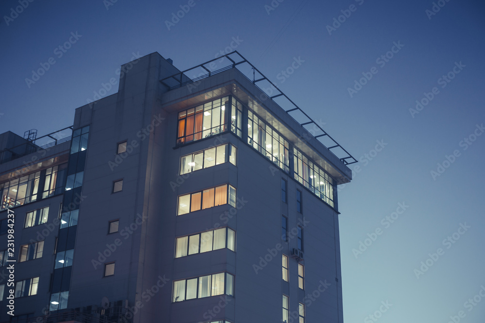 Modern office or residential building in the evening. Viewe from grownd to sky