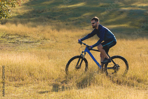 Cyclist in shorts and jersey on a modern carbon hardtail bike with an air suspension fork 